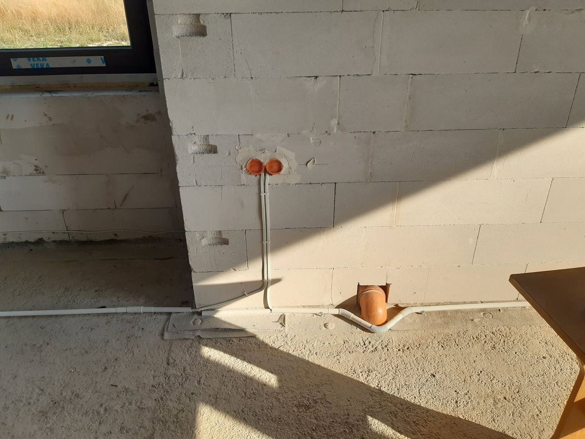 Puszki i przewody instalacji elektrycznej przy oknie w nowym domu jednorodzinnym