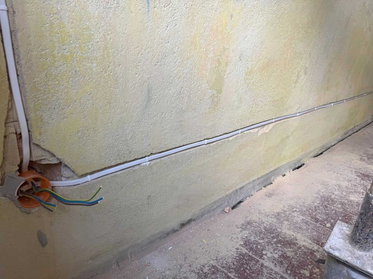 Nowy przewód instalacji elektrycznej poprowadzony w starym budynku podczas remontu